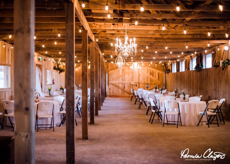 beautiful rustic barn venue with tables and chandeliers 