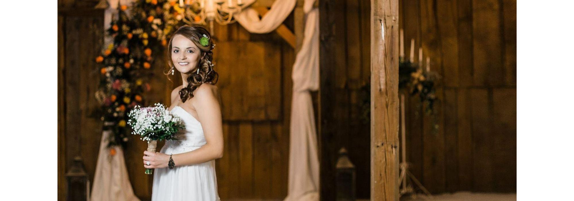 beautiful bride holding bouquet inside barn venue 